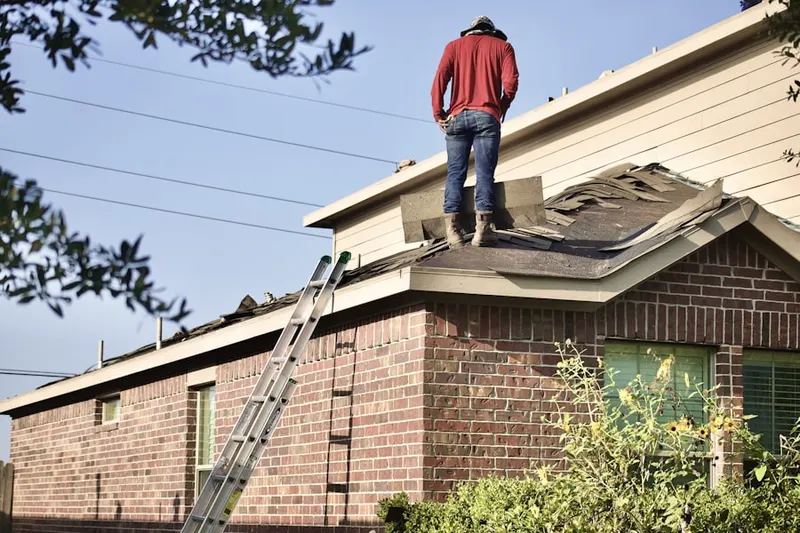 Professional roofer working on a residential roof in Queensgate